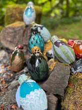 Load image into Gallery viewer, Collection of eight dragon egg potion bottles from alternate angle at stone firepit