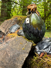 Load image into Gallery viewer, Black and dark green scaled dragon egg potion bottle with golden green shimmer liquid settled, playing card charm