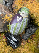 Load image into Gallery viewer, Top angle of mottled gray and moss dragon egg with purple shimmer visible through viewport