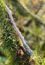 Load image into Gallery viewer, driftwood wand laying on a mossy branch, wand has a daisy inside a resin crystal on one end