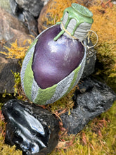 Load image into Gallery viewer, Close-up of mottled gray dragon egg showing bold purple shimmer through glass viewport
