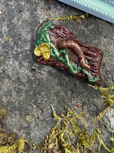 Load image into Gallery viewer, Hand-sculpted polymer clay brooch of an earthworm curled across a mossy stump with golden cup mushrooms, photographed on stone with moss
