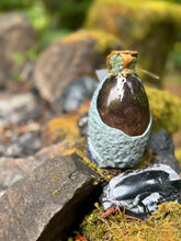 Load image into Gallery viewer, Gray-green mottled dragon egg with spiked tail detail, silver-brushed spines, clear purple liquid settled
