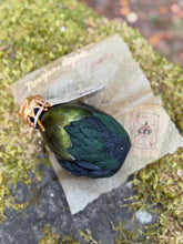 Load image into Gallery viewer, Black and dark green dragon egg potion bottle with golden green shimmer liquid activated
