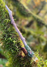 Load image into Gallery viewer, driftwood wand laying on a mossy branch, wand has a daisy inside a resin crystal on one end 
