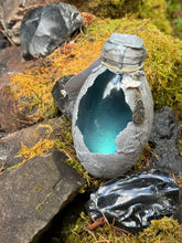 Load image into Gallery viewer, Bronze-brown dragon egg potion bottle with green-golden shimmer liquid activated

