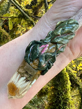 Load image into Gallery viewer, leaf patterned magic wand on driftwood, with daisy inside a resin crystal on it, laying on a person&#39;s hand
