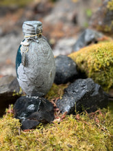 Load image into Gallery viewer, Light gray fossil-textured dragon egg with barely blue liquid settled, labradorite eye charm
